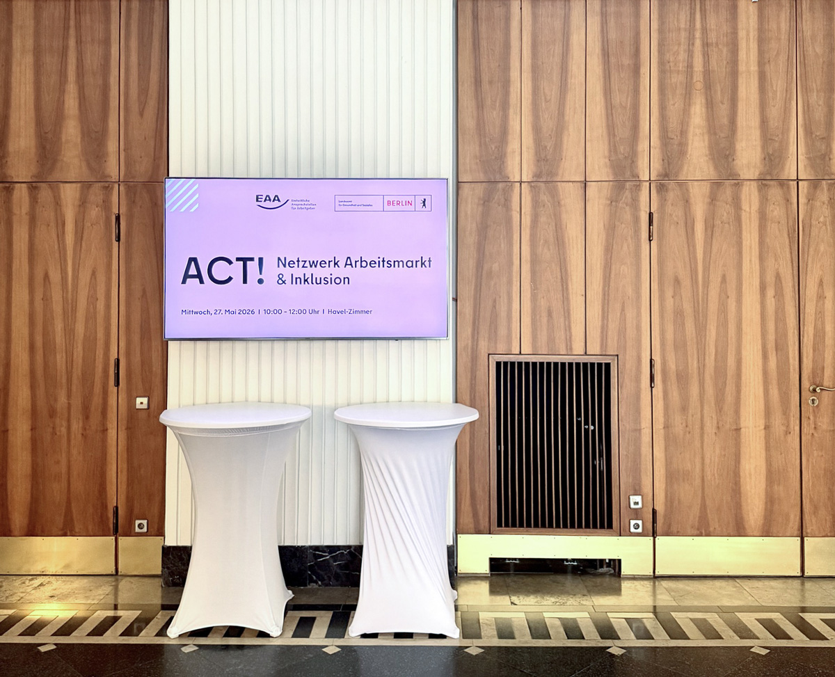 Ein Bildschirm hängt im Foyer im Haus des Handwerks in Berlin und zeigt "ACT! – Netzwerk Arbeitsmarkt und Inklusion"